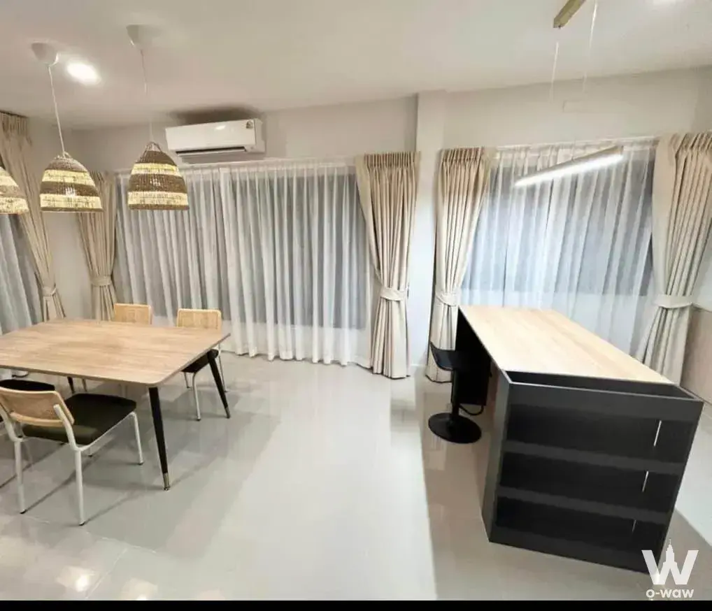 Grande Pleno townhouse dining area with light-wood table, woven chairs, and pendant lights