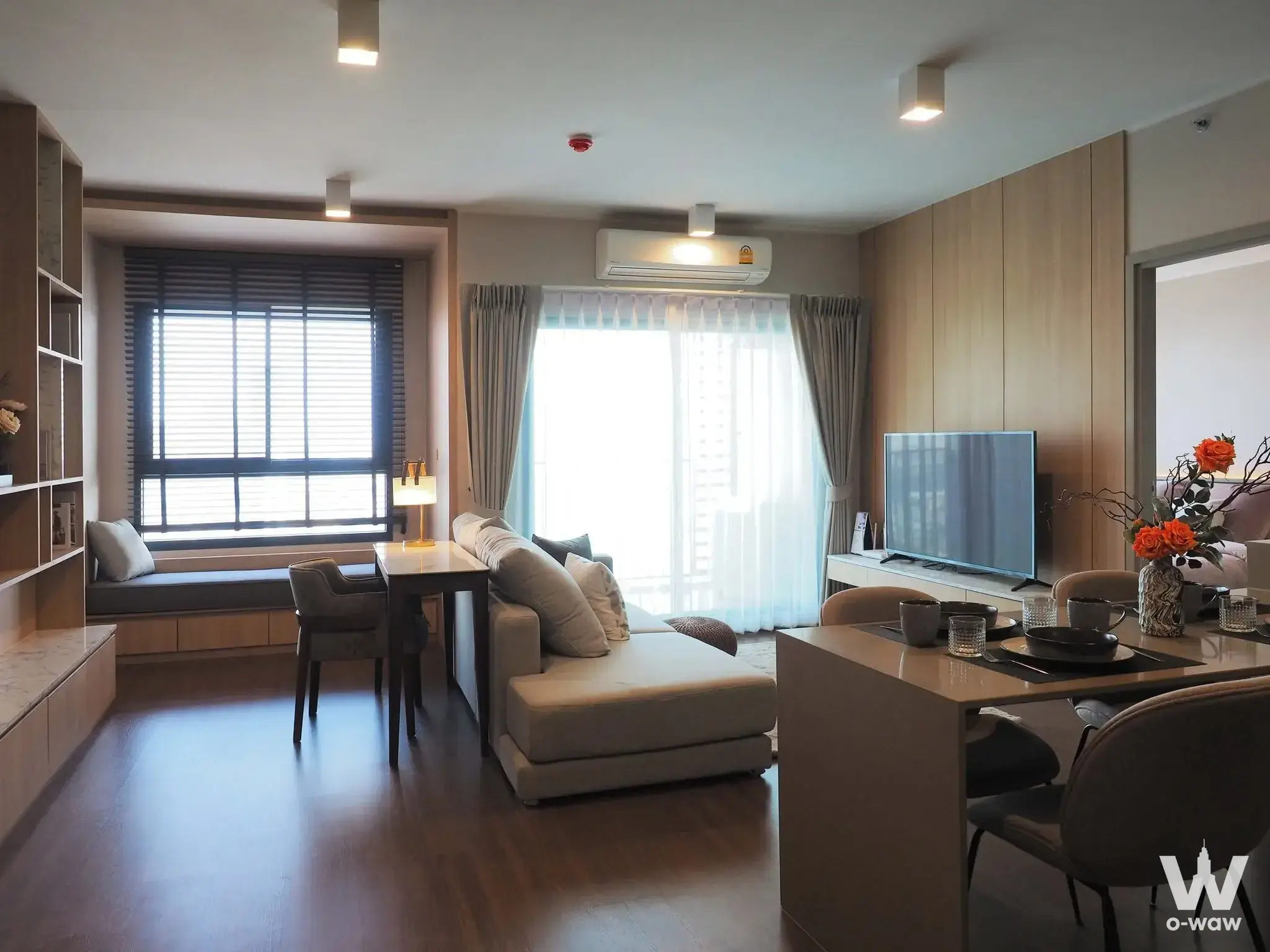 Ideo Sukhumvit 93 open-plan living area with L-shaped sofa and dining setup