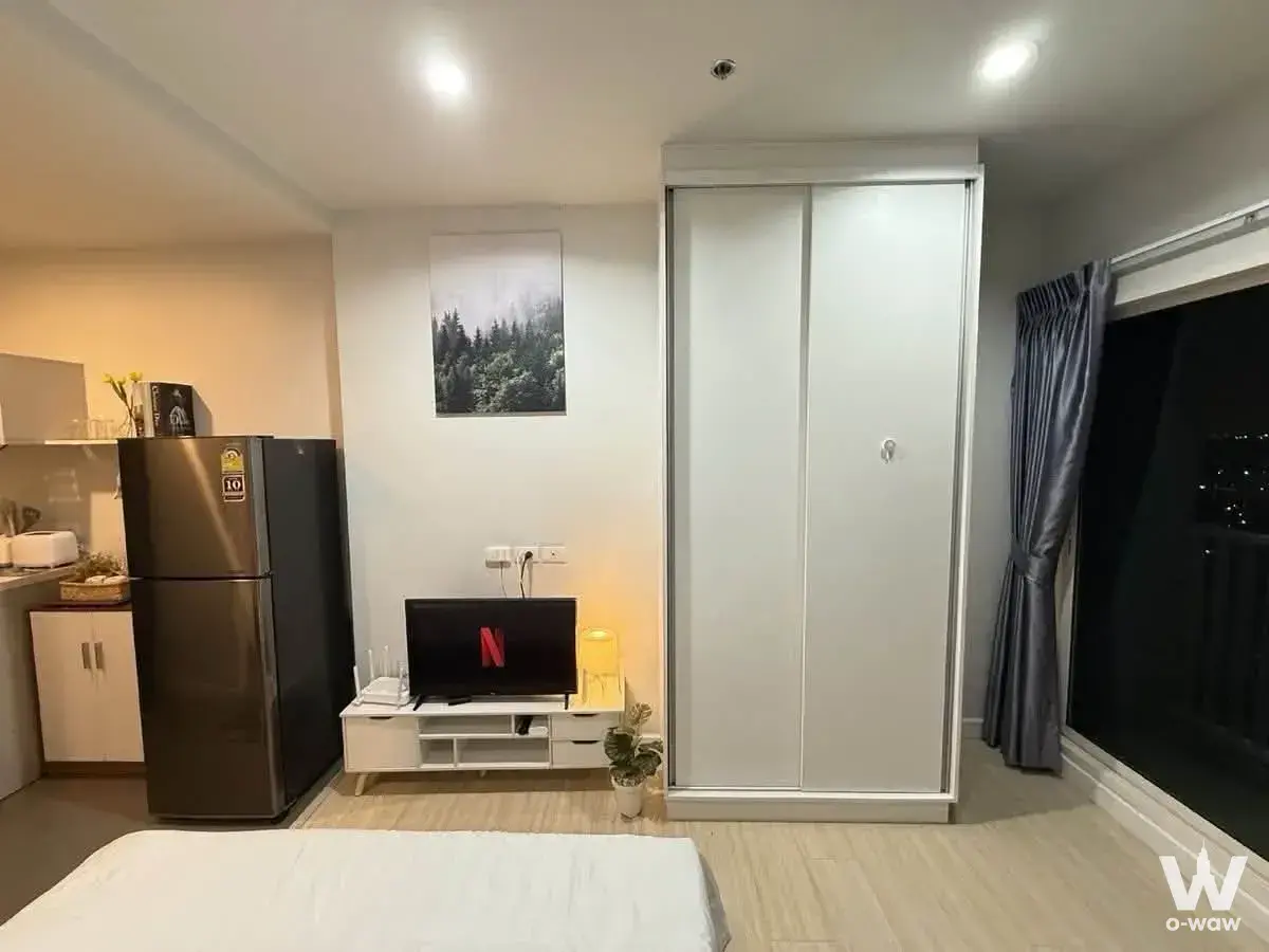 Compact furnished studio in Metro Sky Wutthakat with queen bed, kitchenette, and city lights view