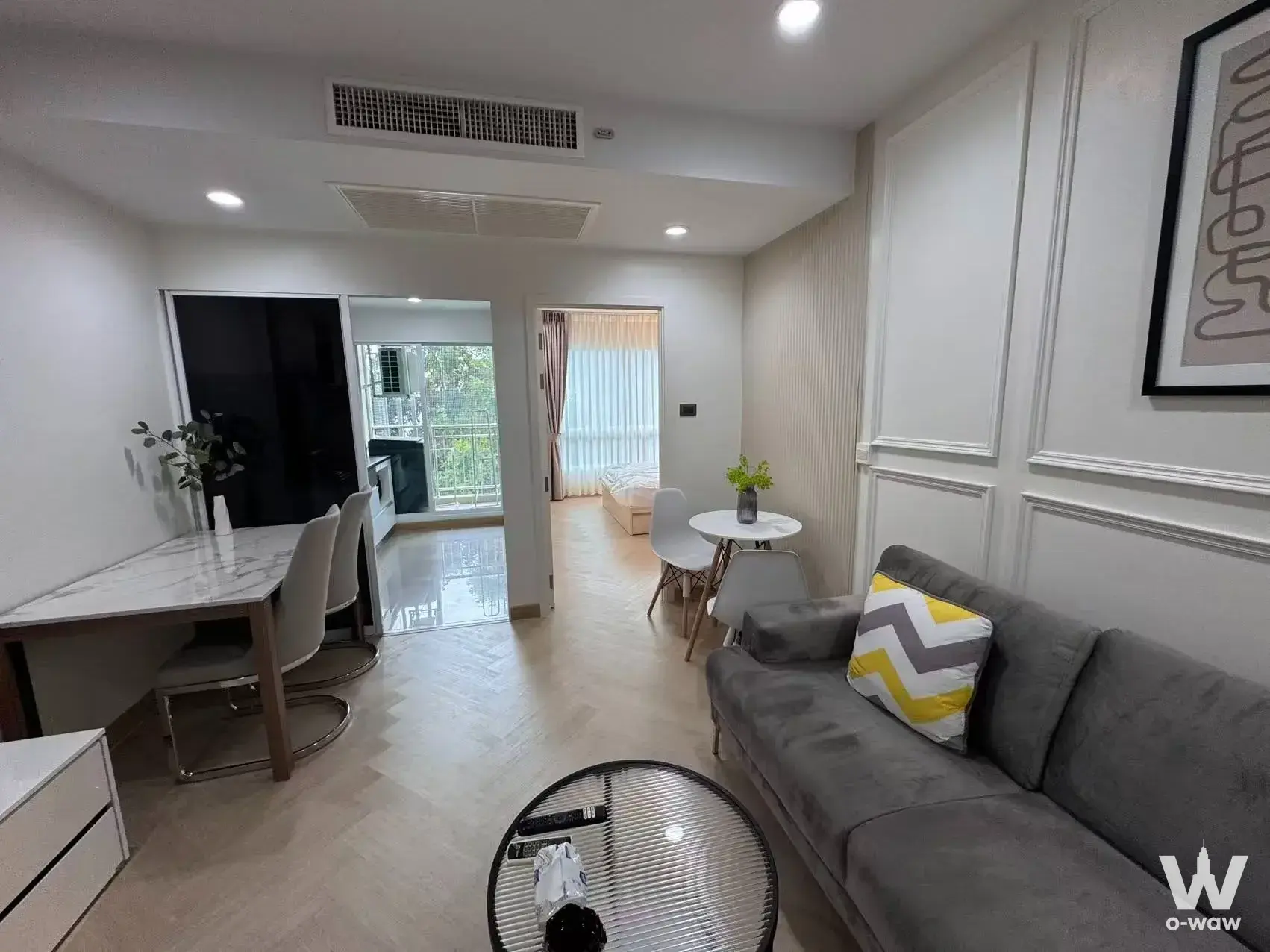 Furnished living room in Supalai Wellington II with herringbone floor and balcony view