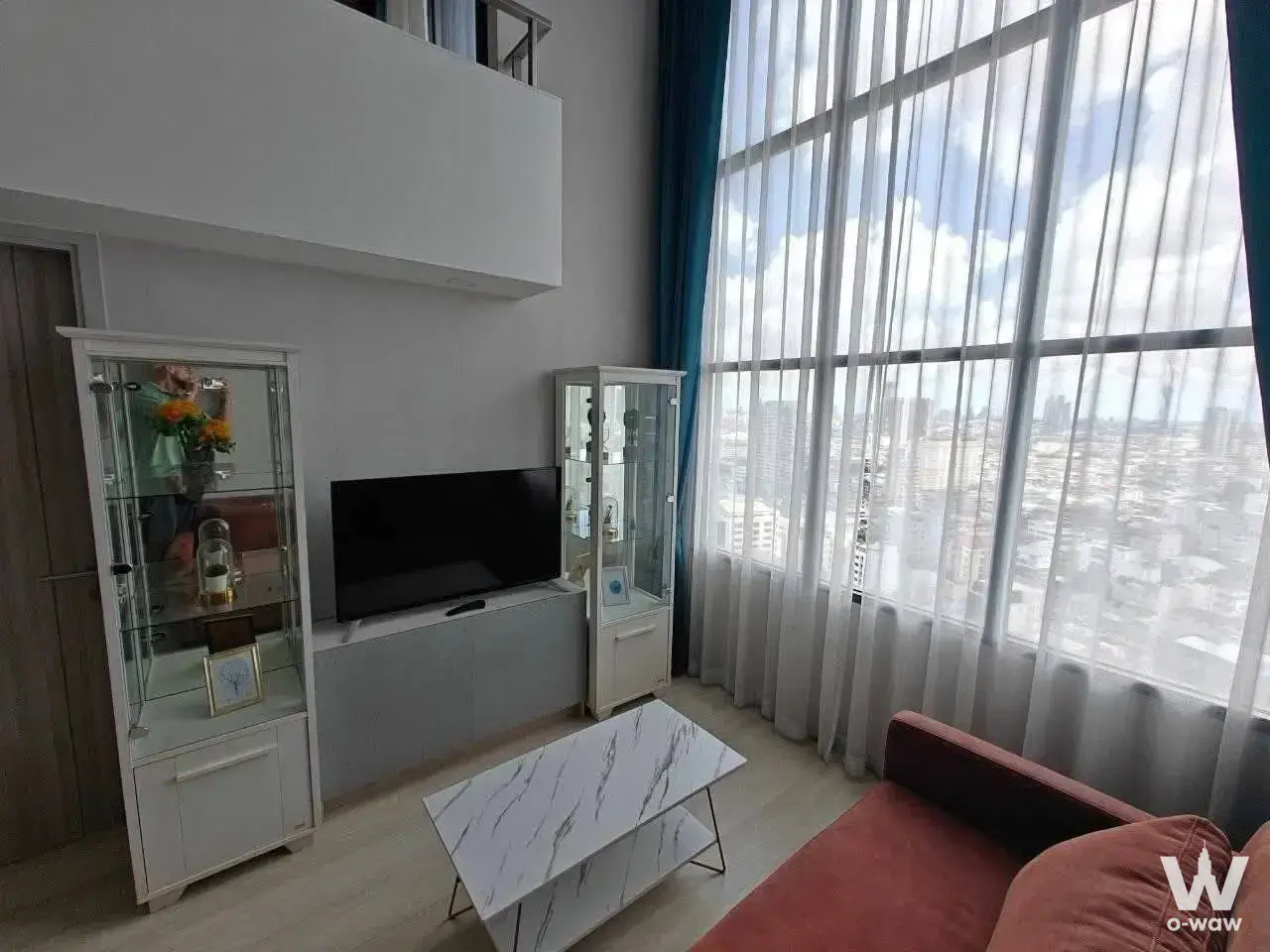 Double-height living room in KnightsBridge Prime Sathon with city skyline view