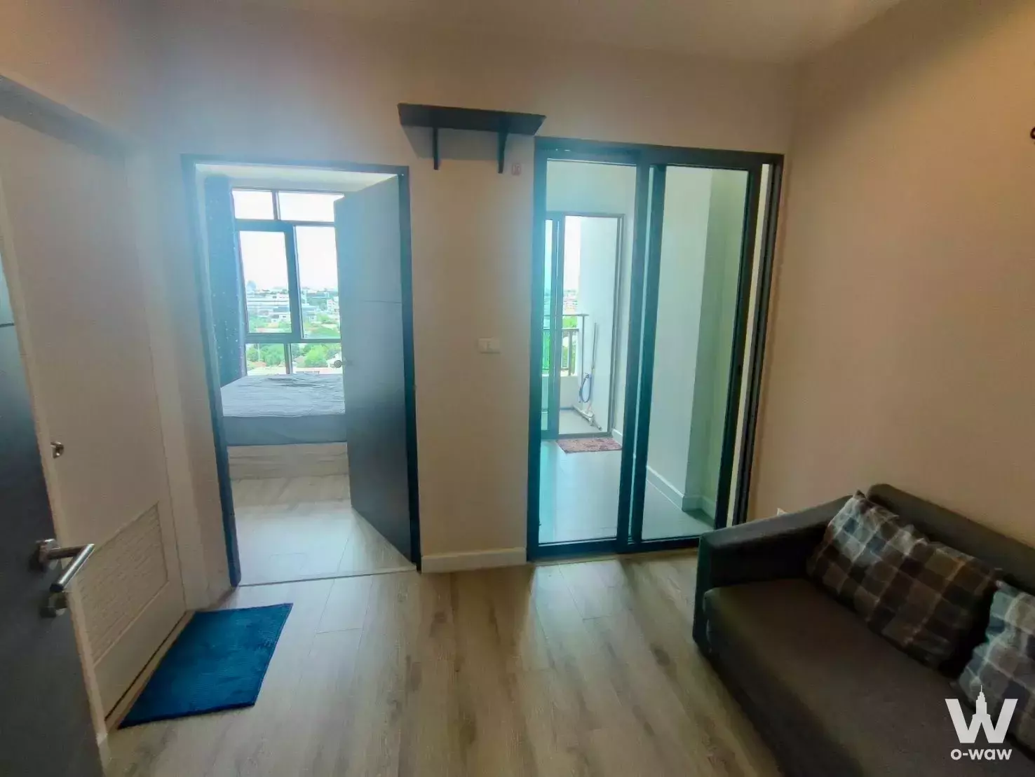 1-bed condo for sale in Metro Sky Prachachuen with a beige living room, leather sofa, and balcony access