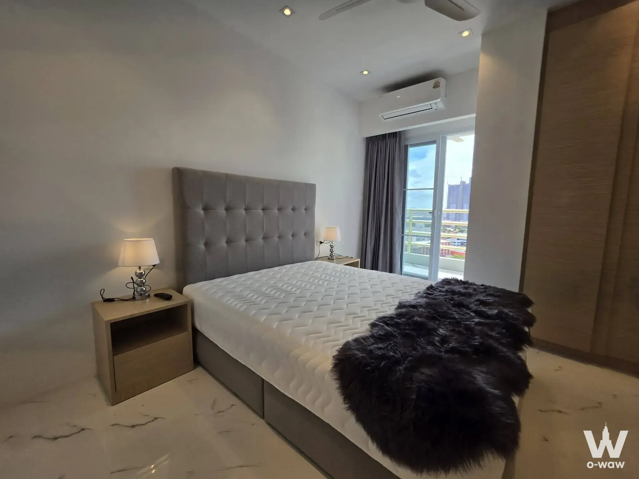 2-bed condo bedroom for sale in View Talay 5C featuring tufted headboard, marble-look floor, and balcony access