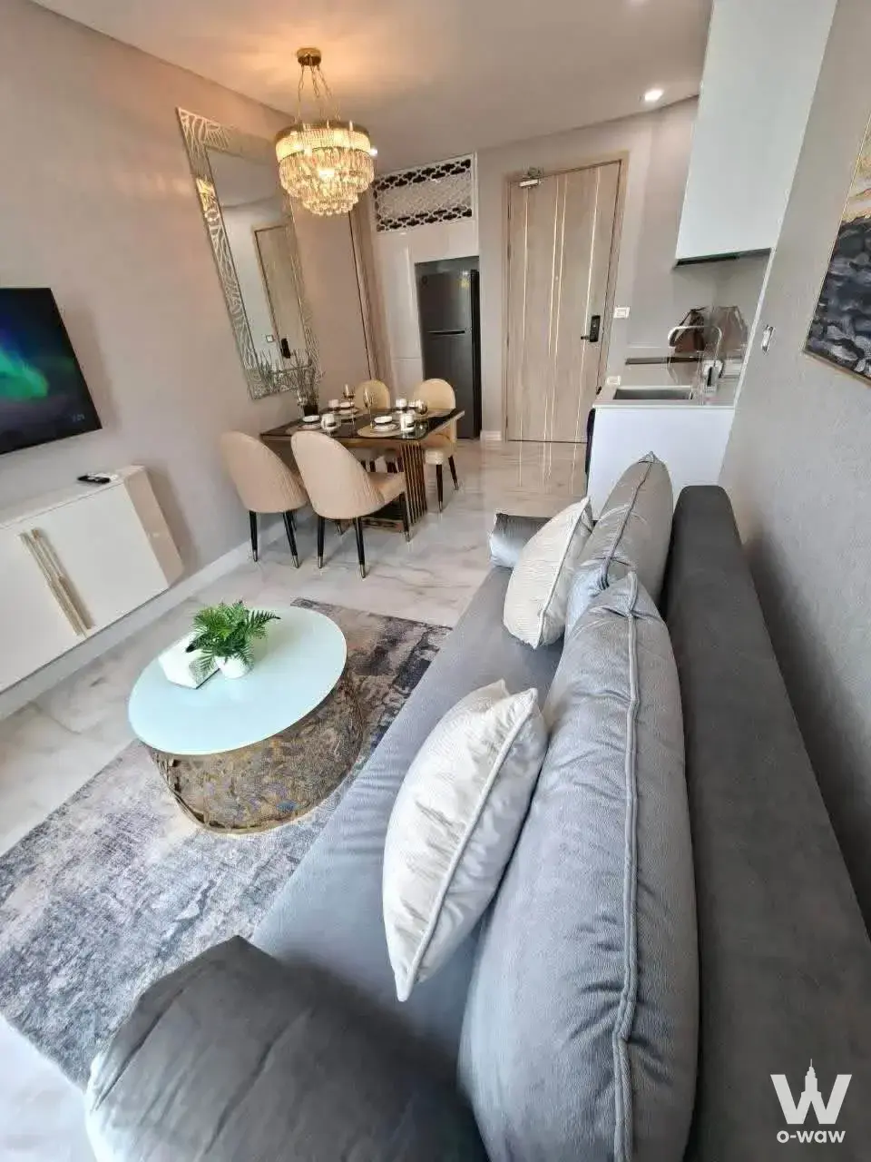Furnished open-plan living and dining area with crystal chandelier in Copacabana Beach Jomtien