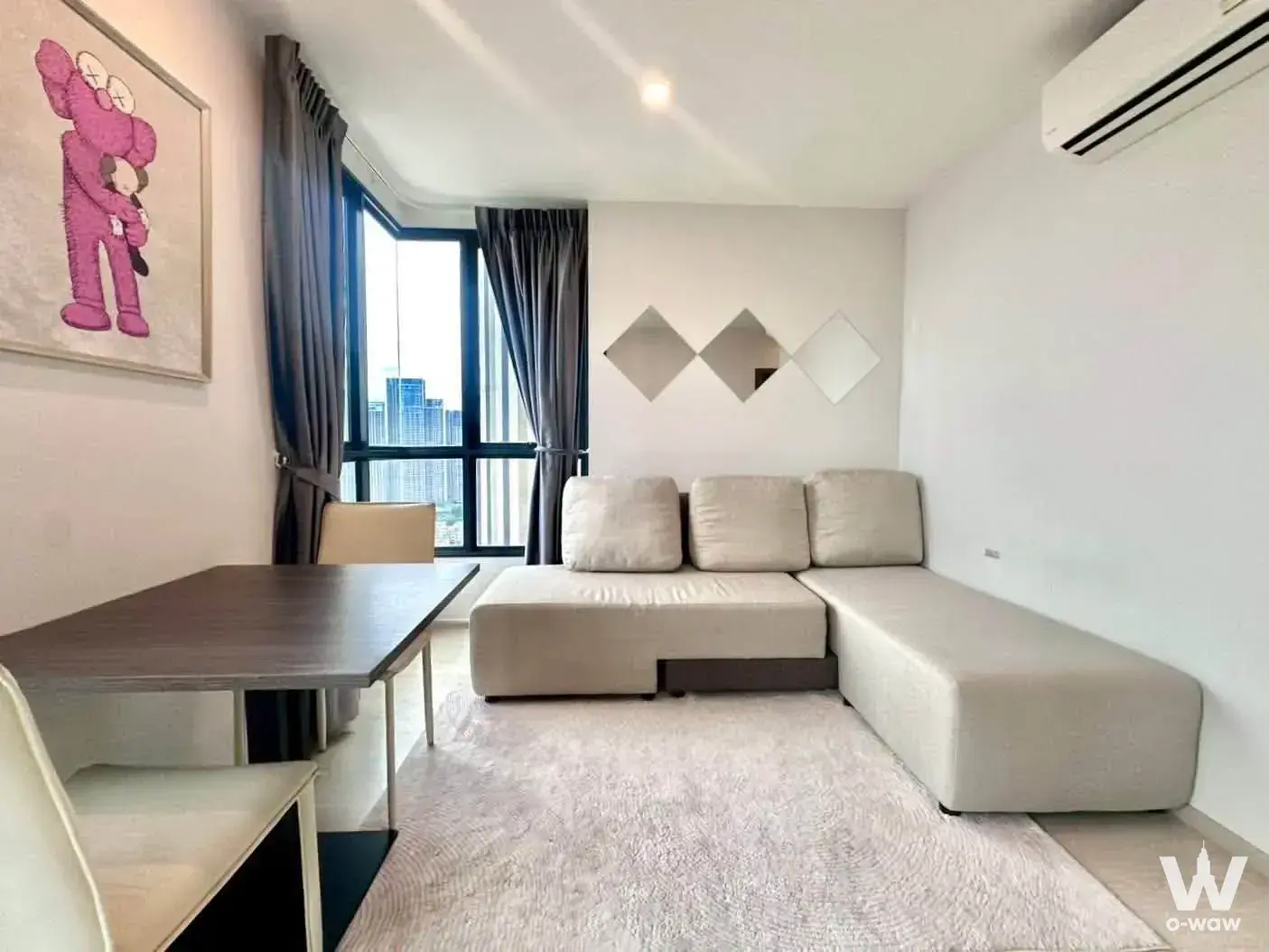 Beige sectional sofa and pink artwork in a 1-bed condo for rent at ELIO DEL NEST