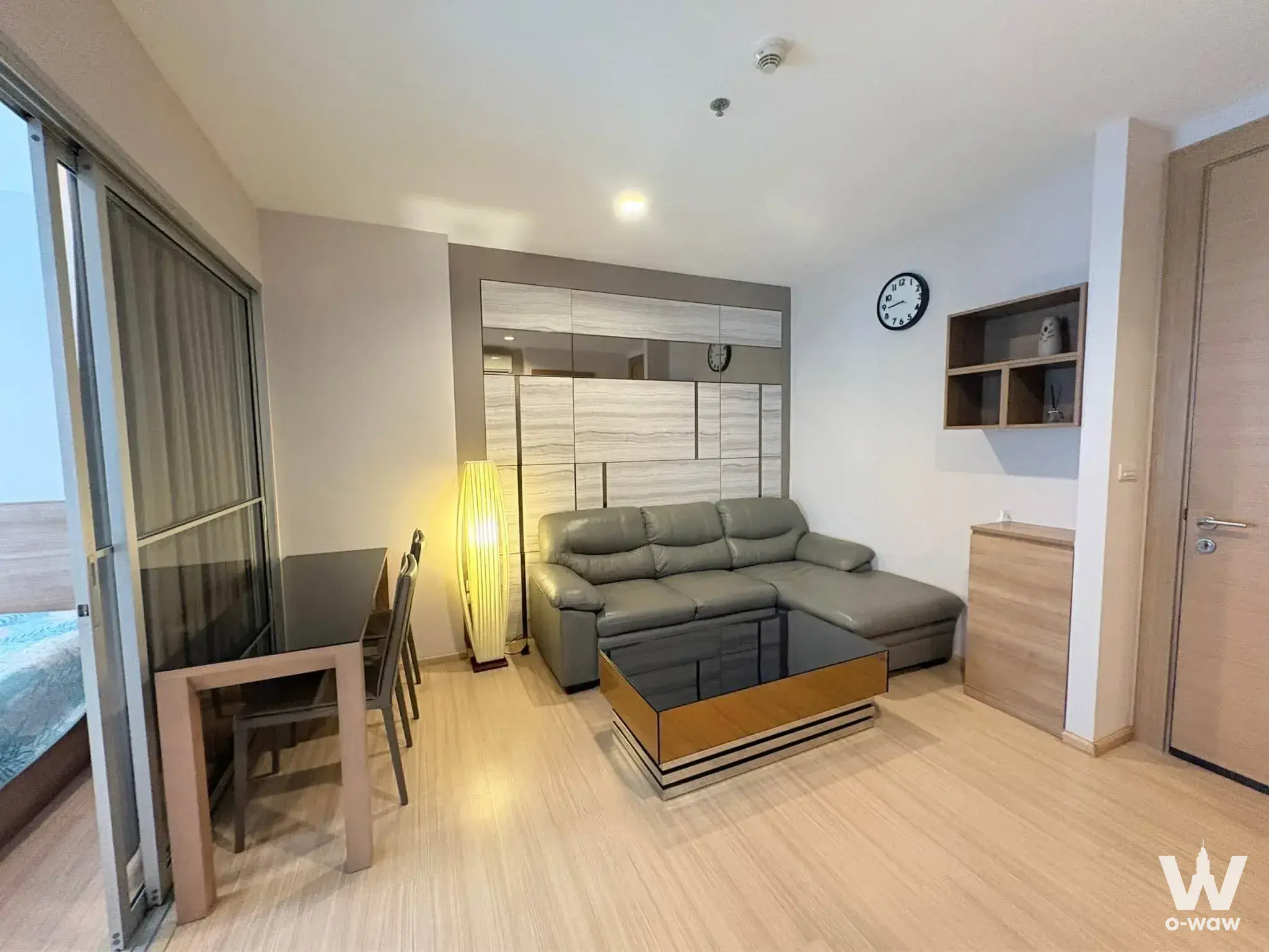 Grey sectional sofa and dining set in RHYTHM Ratchada 1-bed condo living room