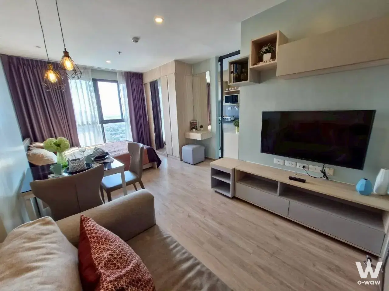 Ideo O2 1-bed condo open-plan living area with sofa, dining table, and city views