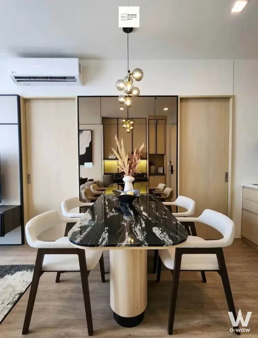 Luxury dining area in Noble State 39 with black marble table, cream chairs, and smoked glass pendant lights