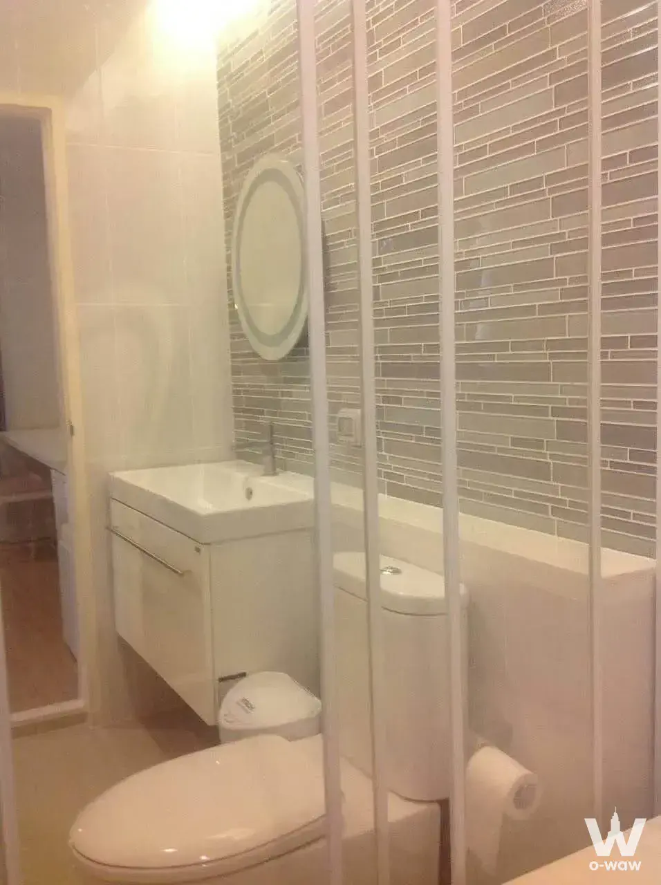 Compact bathroom in a Life @ Ladprao 18 condo featuring grey mosaic tiles and a built-in bathtub