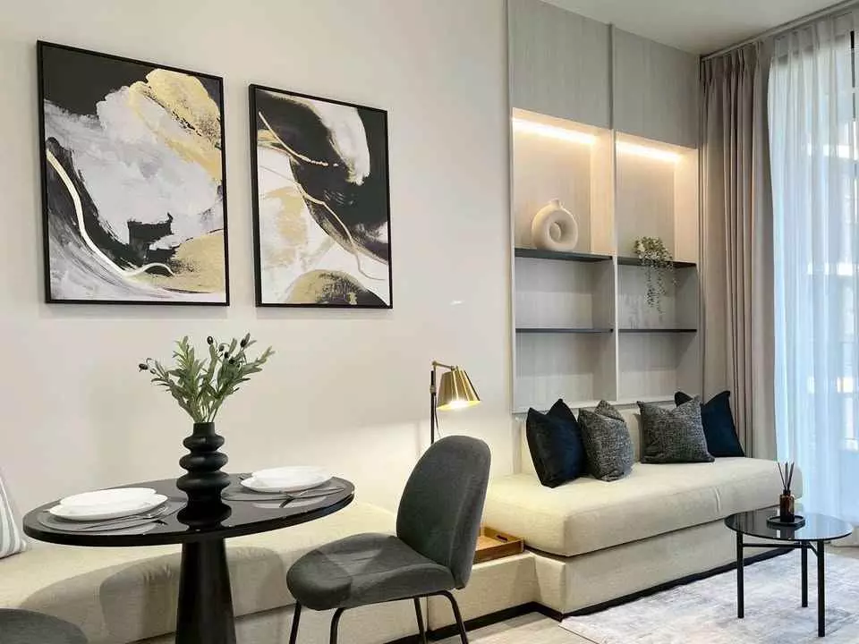 Chapter Charoennakhon living room with cream banquette, navy pillows, and floor-to-ceiling riverside windows