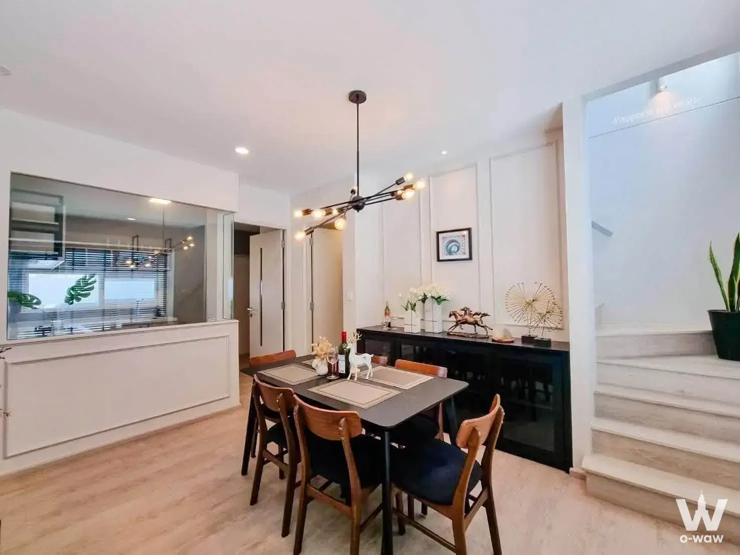 Dining area with black chandelier and sideboard in a 2-bed house for sale at Anya Bangna-Ramkamhaeng 2