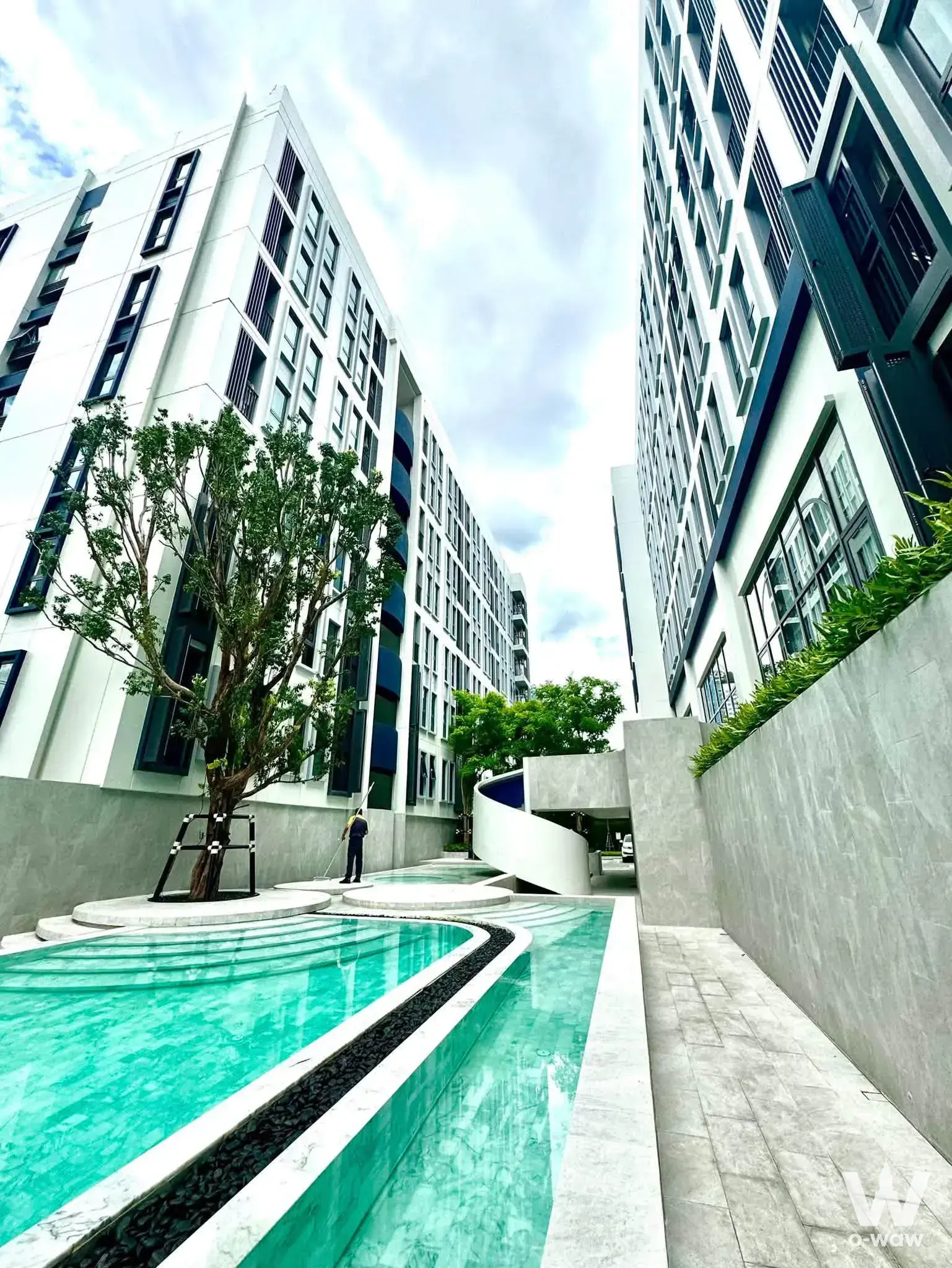 Turquoise reflecting pool and white marble edging at Aspire Ratchayothin 1-bed rental