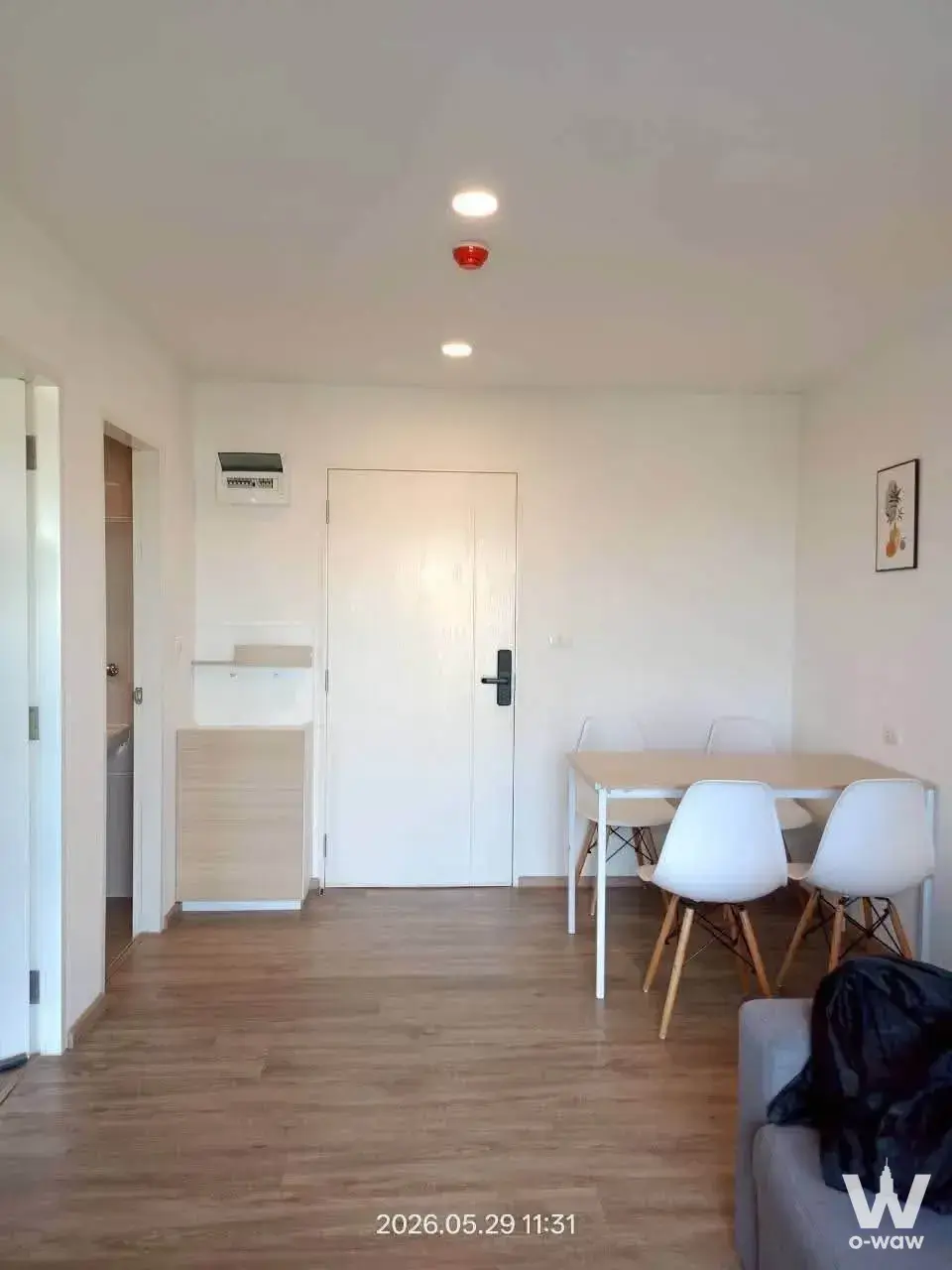 Open-plan dining area in a Sena Kith Srinakarin-Sridan 2-bed condo with a light wood table and white chairs