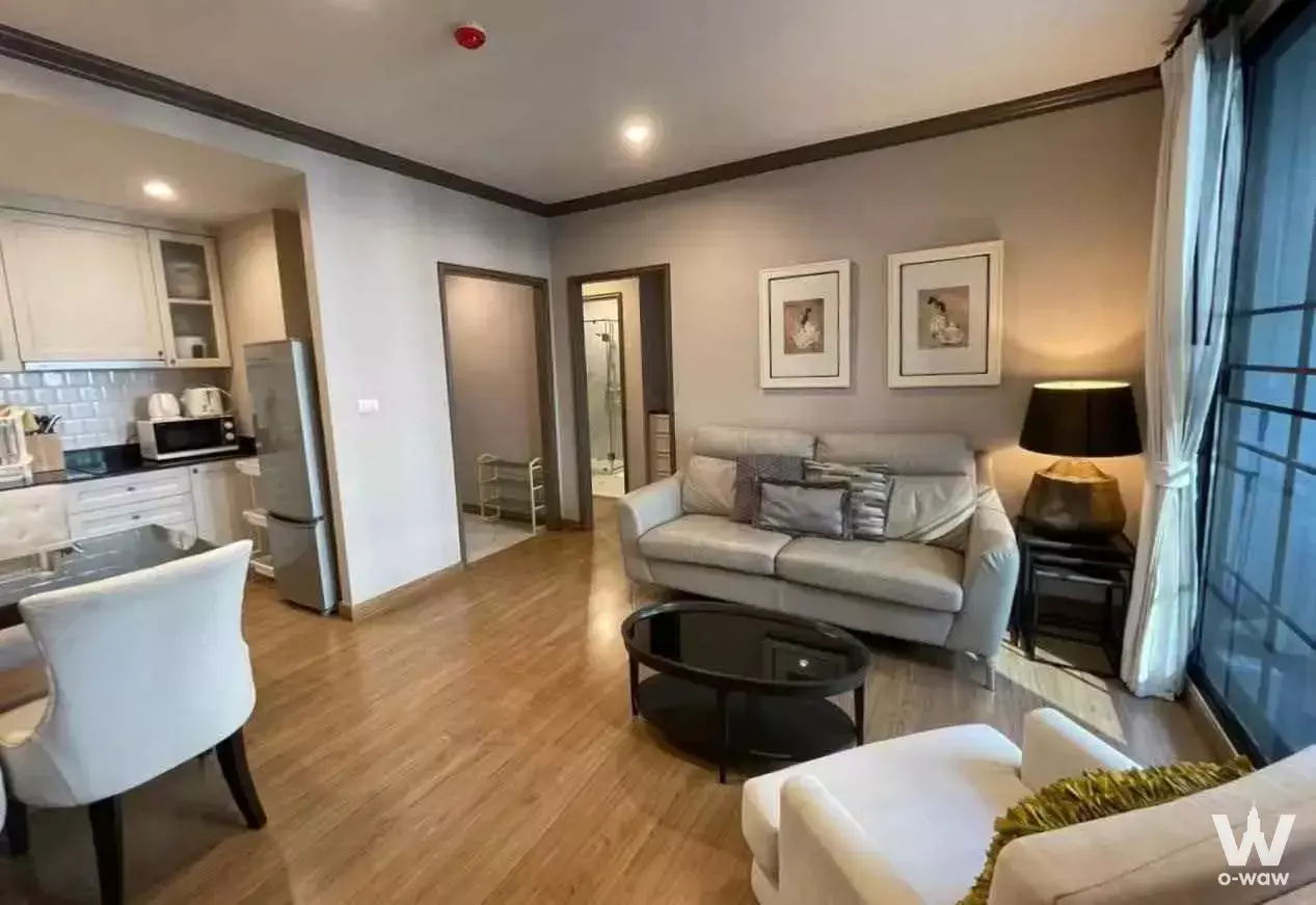 2-bed condo for rent in The Reserve Kasemsan 3 with open-plan living, light oak flooring, and floor-to-ceiling windows