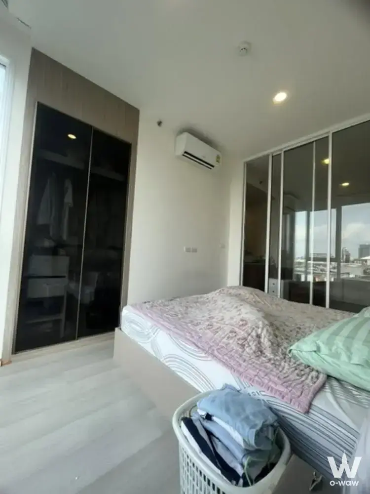De Lapis Charan 81 Bangkok 1-bed condo bedroom for sale with dark wood wardrobe and pink accents