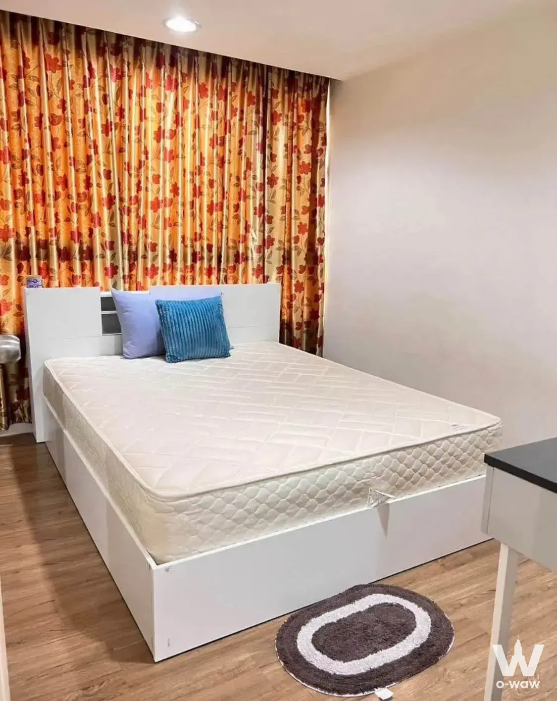 Bedroom with platform bed and patterned curtains in The Kris 5 Ratchada 17