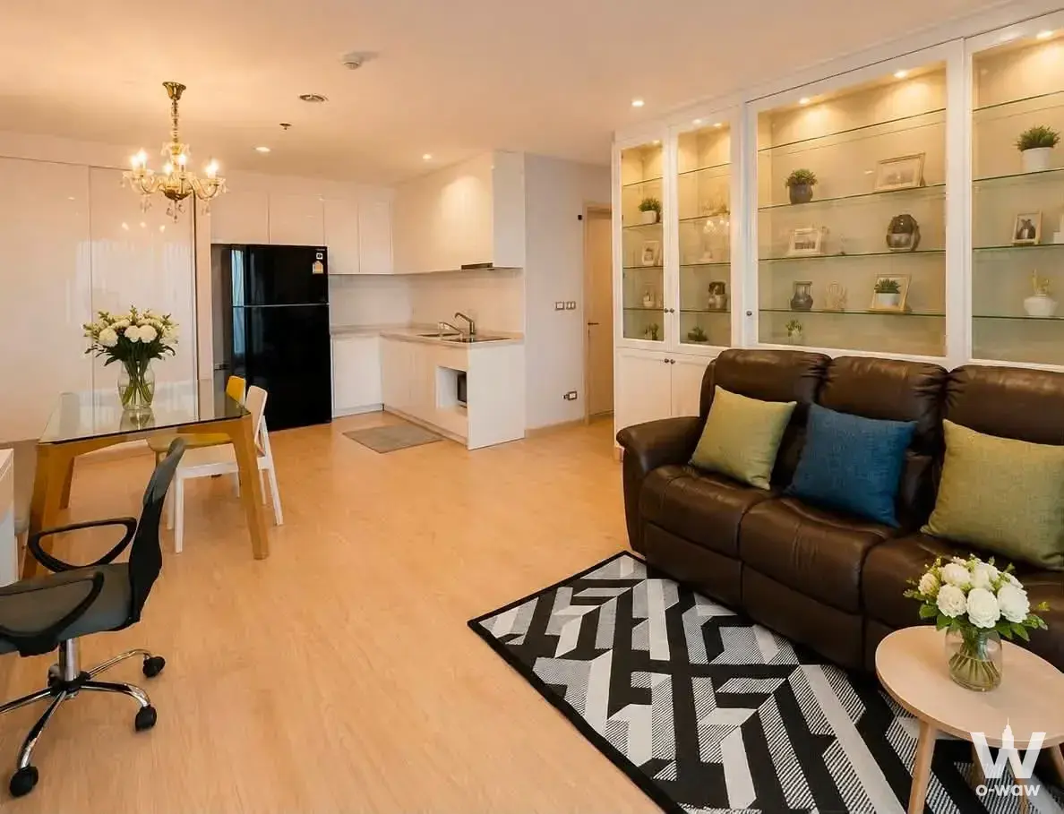 Open-plan space in Rhythm Sukhumvit 42 featuring a leather sofa and white high-gloss kitchen cabinets