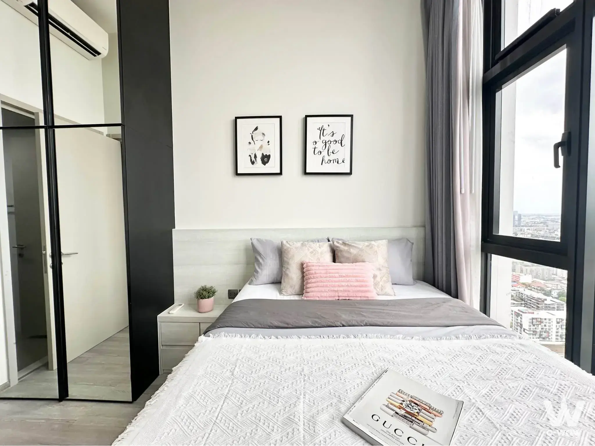 Queen bedroom in THE LINE Sukhumvit 71 offering a high-floor city skyline view through large windows