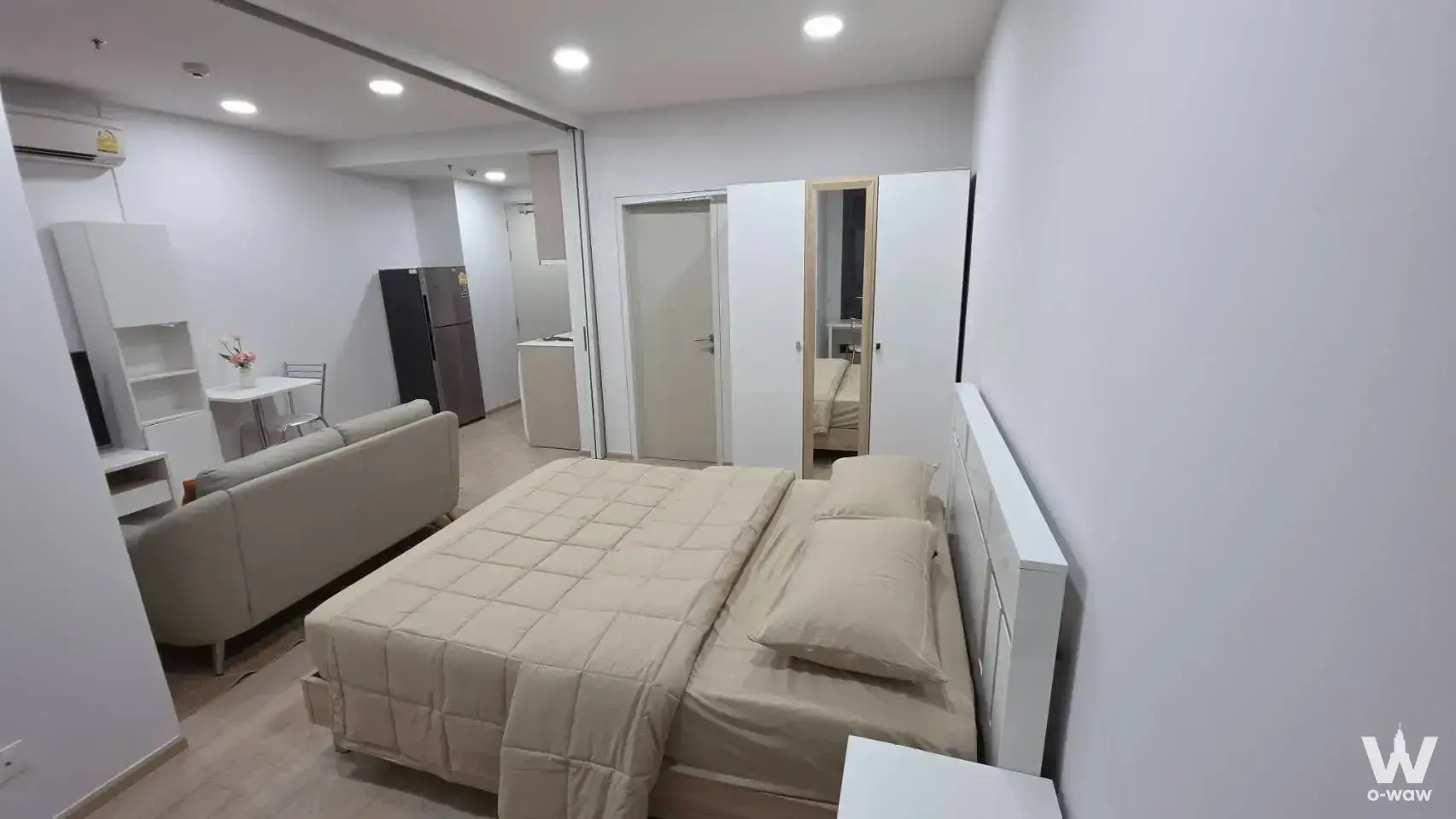 Furnished studio in Ideo Q Ratchathewi featuring open-plan living area, kitchenette, and queen bed