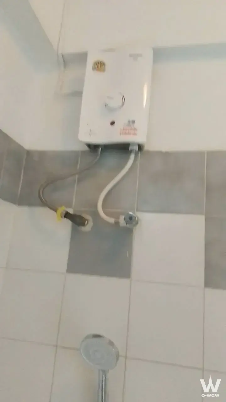 Functional bathroom shower area in นนท์ซิตี้ทาวเวอร์ with grey checkerboard tiles and chrome fixtures