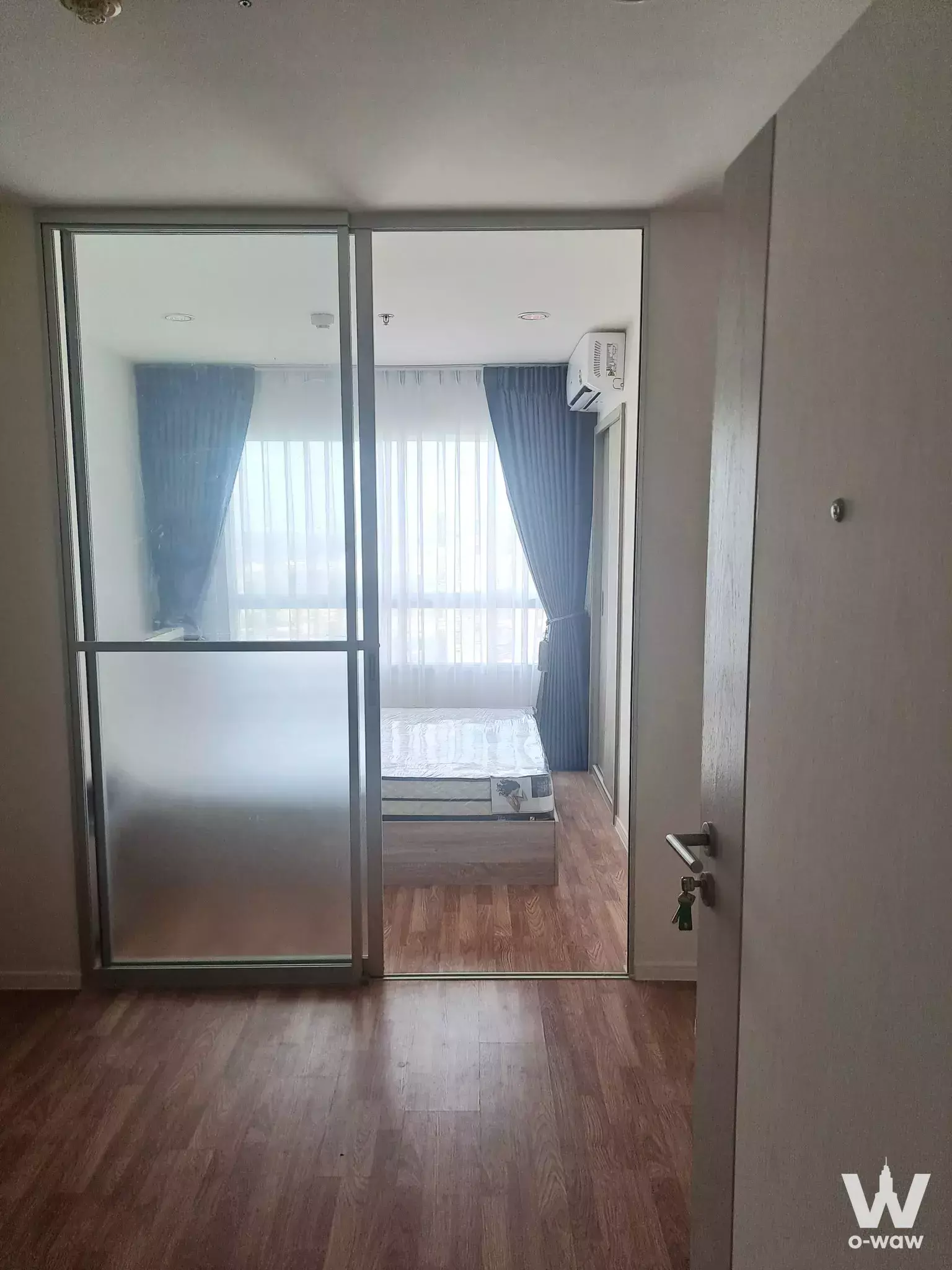 Unfurnished bedroom in Lumpini Park Phetkasem 98 with bare mattress and floor-to-ceiling windows