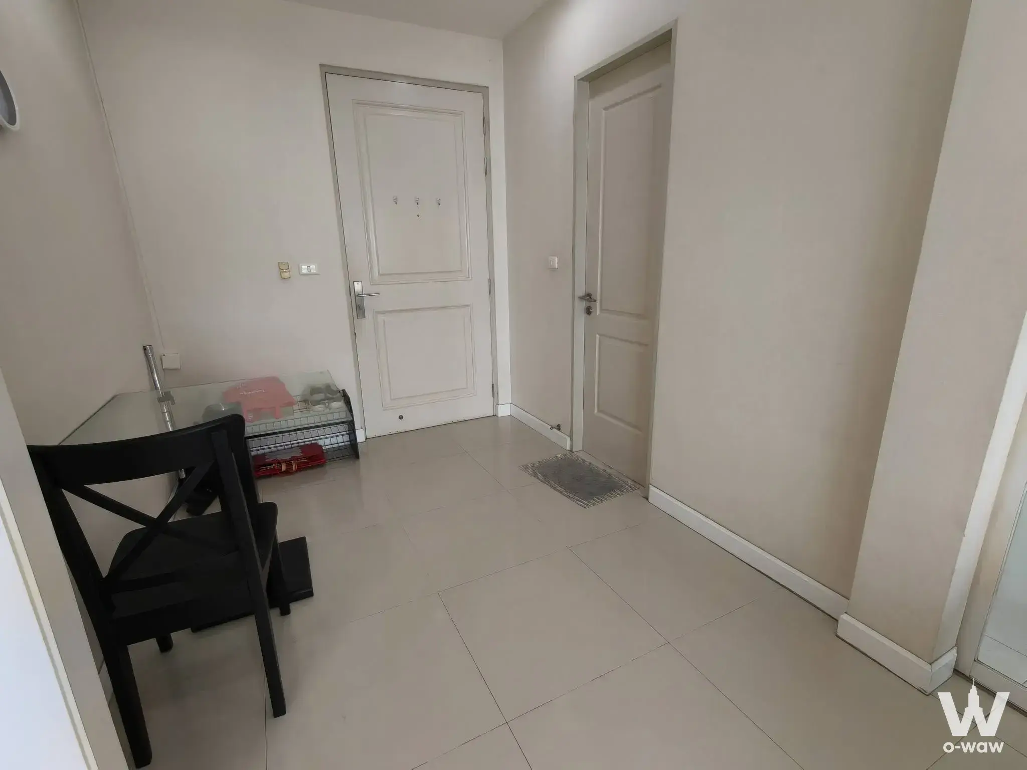 Entryway of a 1-bed Sathon rental with glossy beige tile floors and cream recessed-panel doors