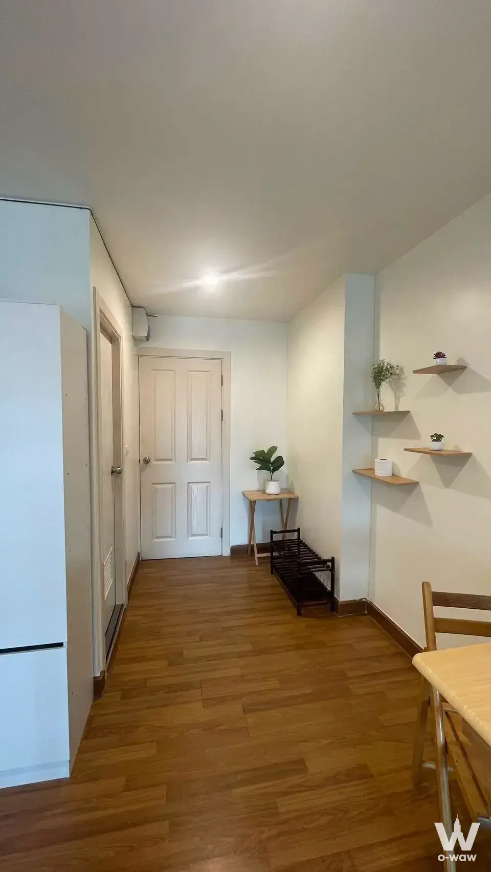 Entry hallway in Regent Home 18 with wood-look laminate flooring, white wardrobe, and minimalist decor