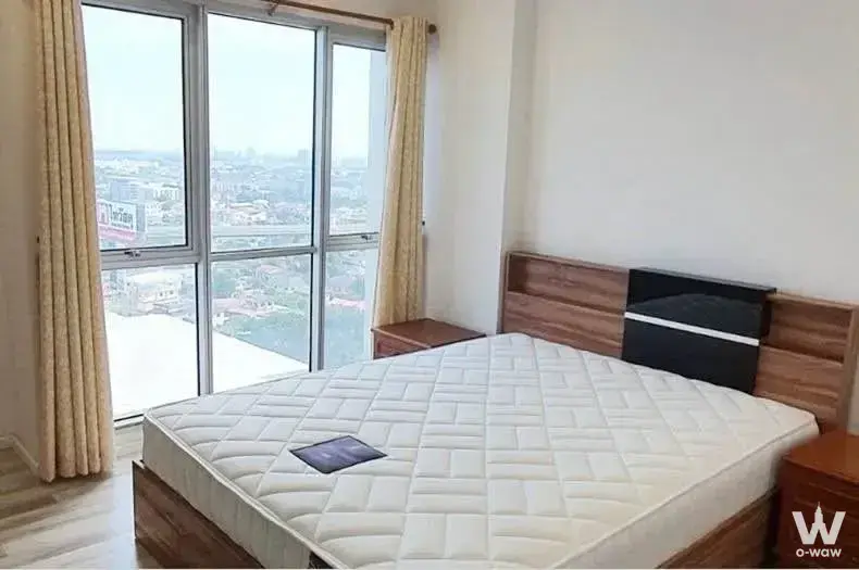 1-bed condo for sale in The Key Cheangwattana bedroom with wood bed, nightstands, and city skyline view