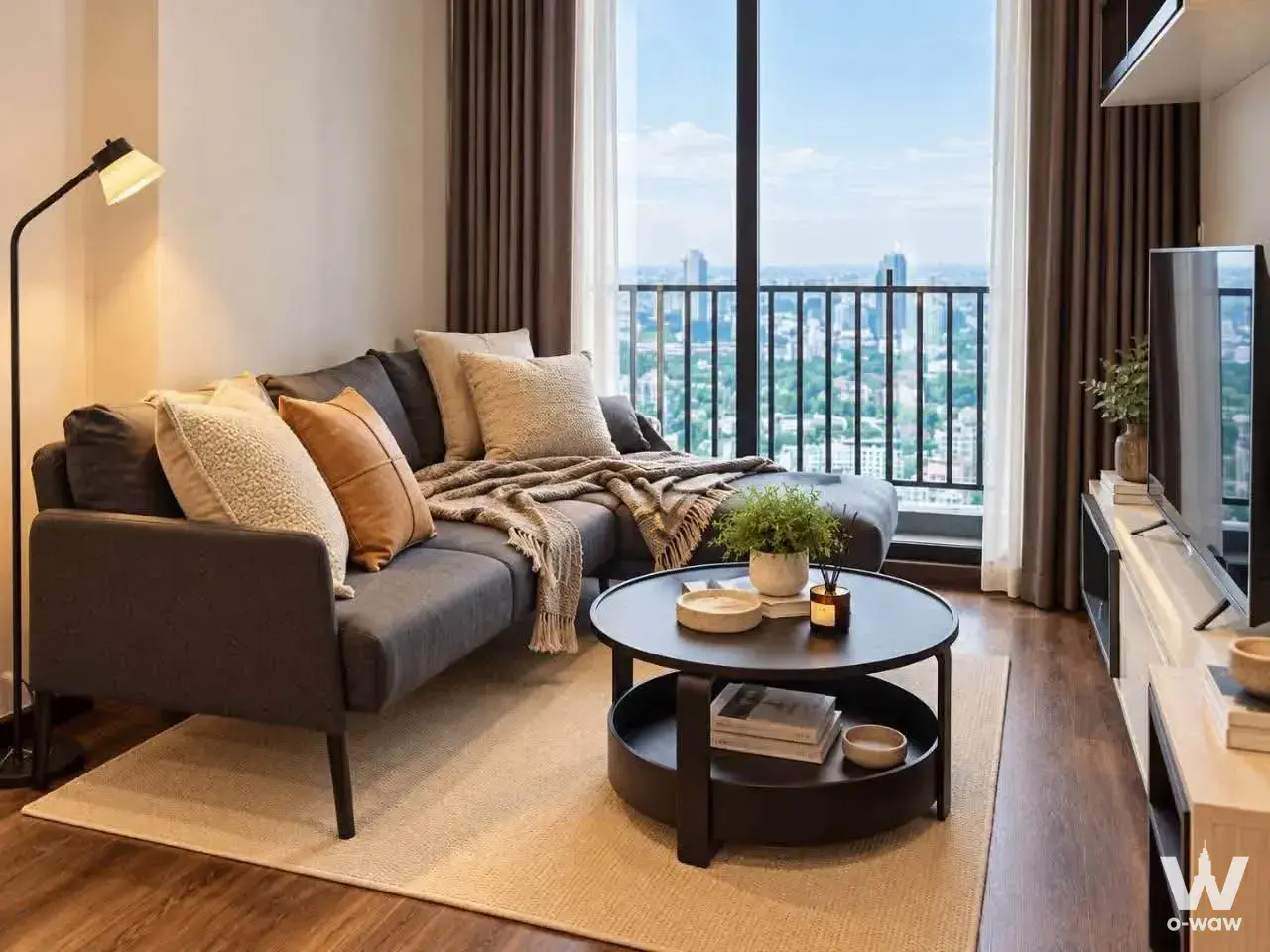 Living room in a 1-bed rental condo in Thonglo with a grey sectional sofa and floor-to-ceiling glass door to a city view