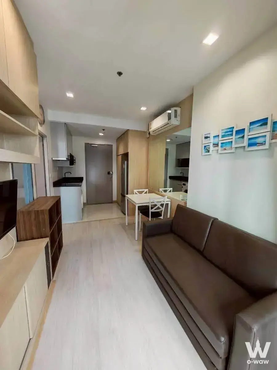 Open-plan studio in Ideo Mobi Sukhumvit 81 with dining area, kitchenette, and built-in wooden cabinetry