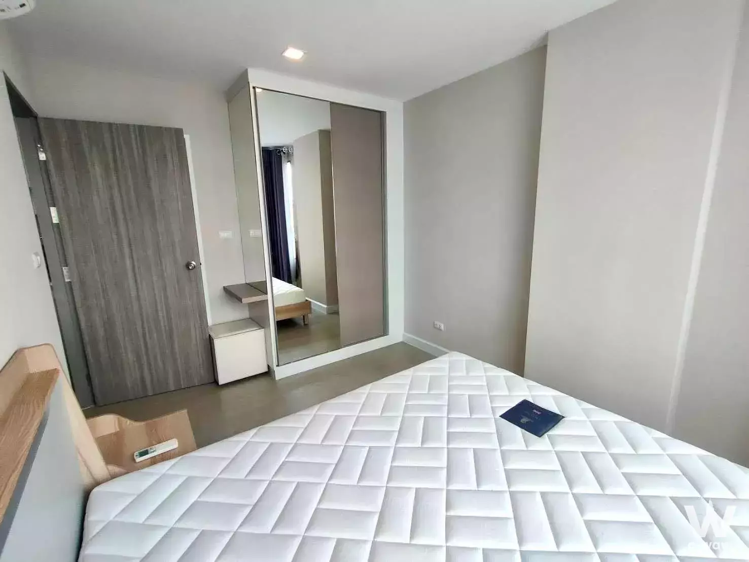 Unfurnished bedroom in Metro Luxe Ratchada with a queen bed, built-in wardrobe mirror, and floating desk