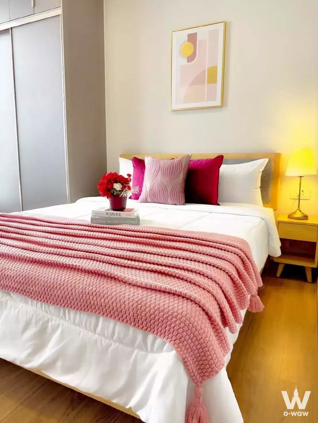 Queen bed with pink knit throw and abstract art in this 1-bed condo for rent in Cloud Thonglor-Phetchaburi