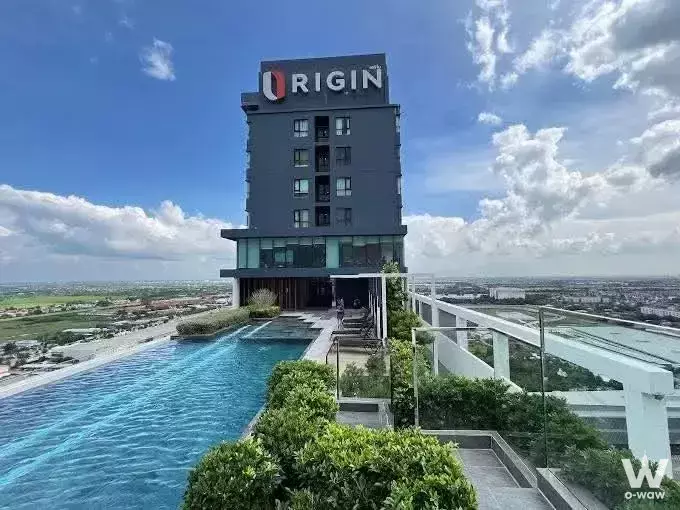 Rooftop infinity pool at The Origin Ram 209 Interchange condo with lounge chairs and city views