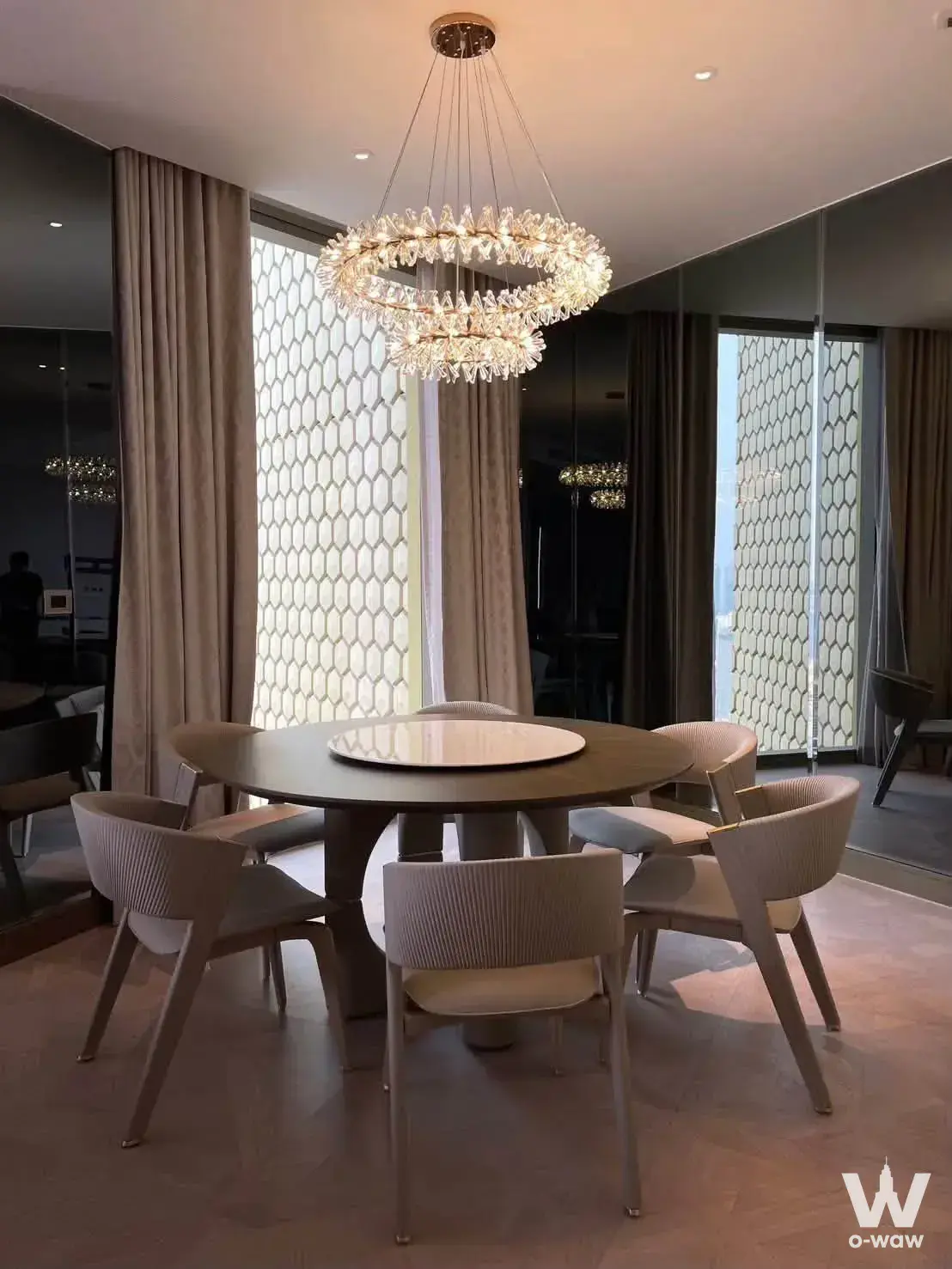 Dining room in The Residences at Mandarin Oriental Bangkok condo with crystal chandelier and round table