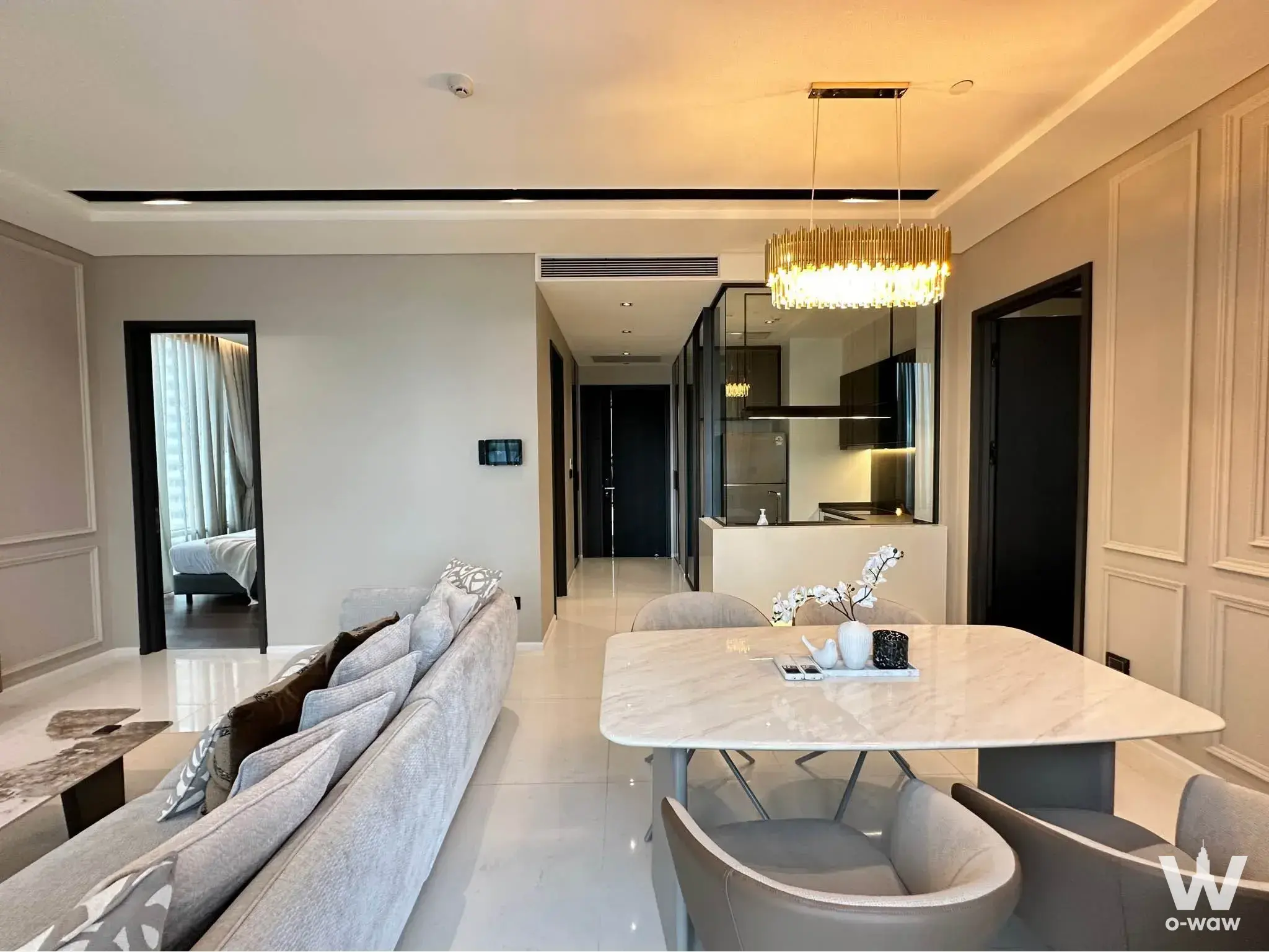 Luxury dining area in The Bangkok Thonglor featuring a marble table and gold chandelier