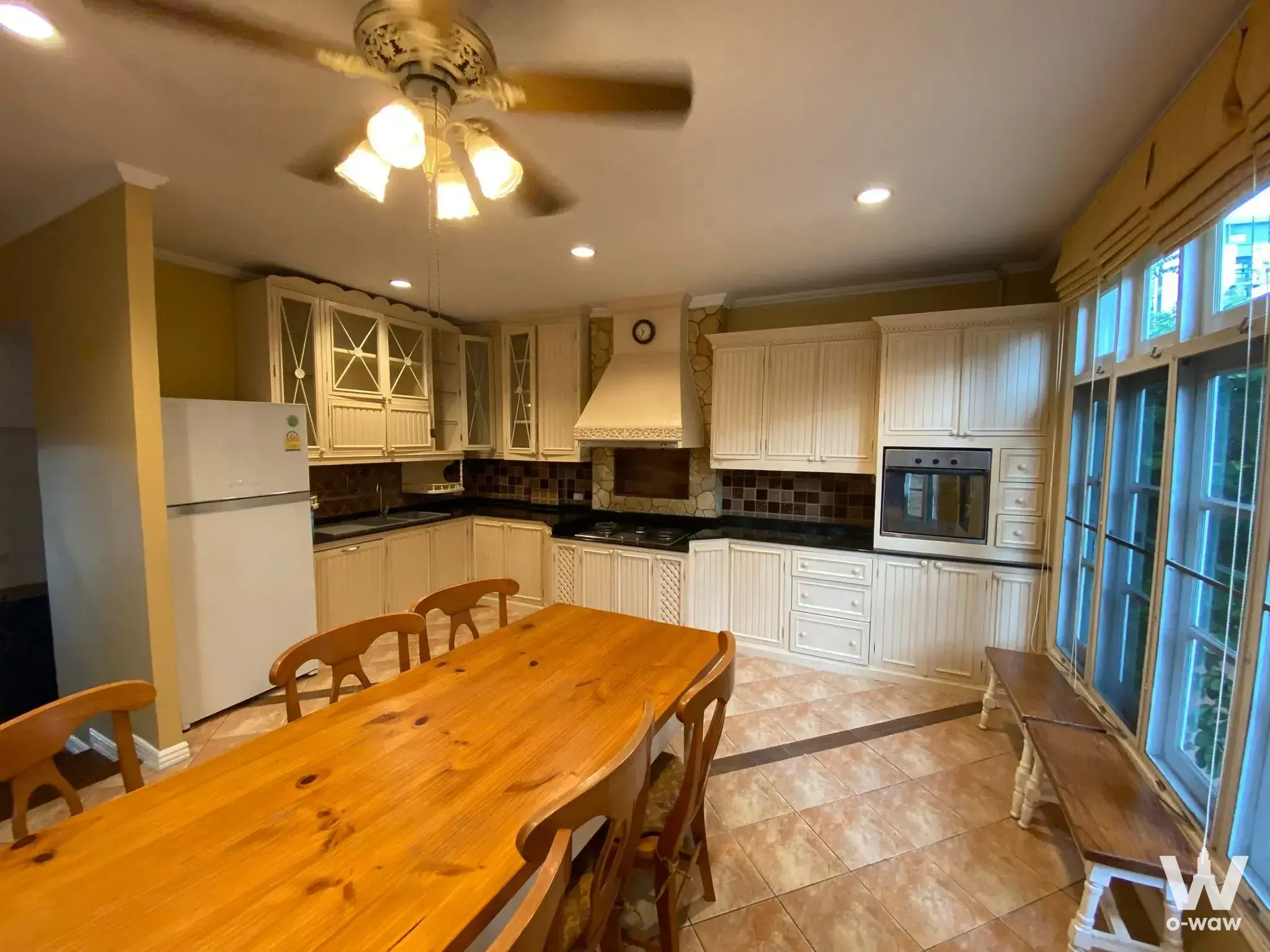 Traditional kitchen dining area featuring cream cabinetry, granite counters, and a large wooden table