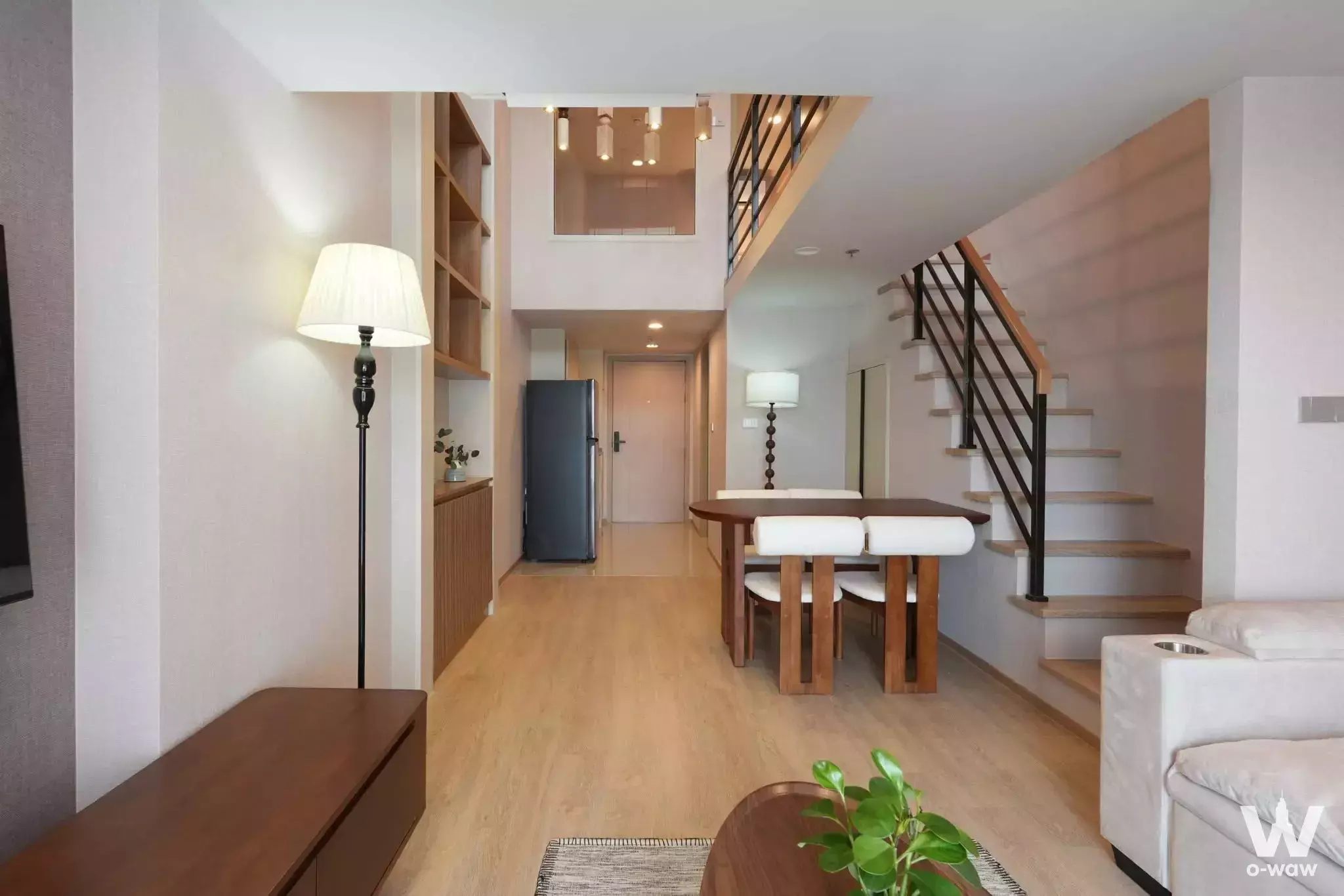Duplex loft in Coco Parc with open living area, floating staircase, and modern Scandinavian furniture