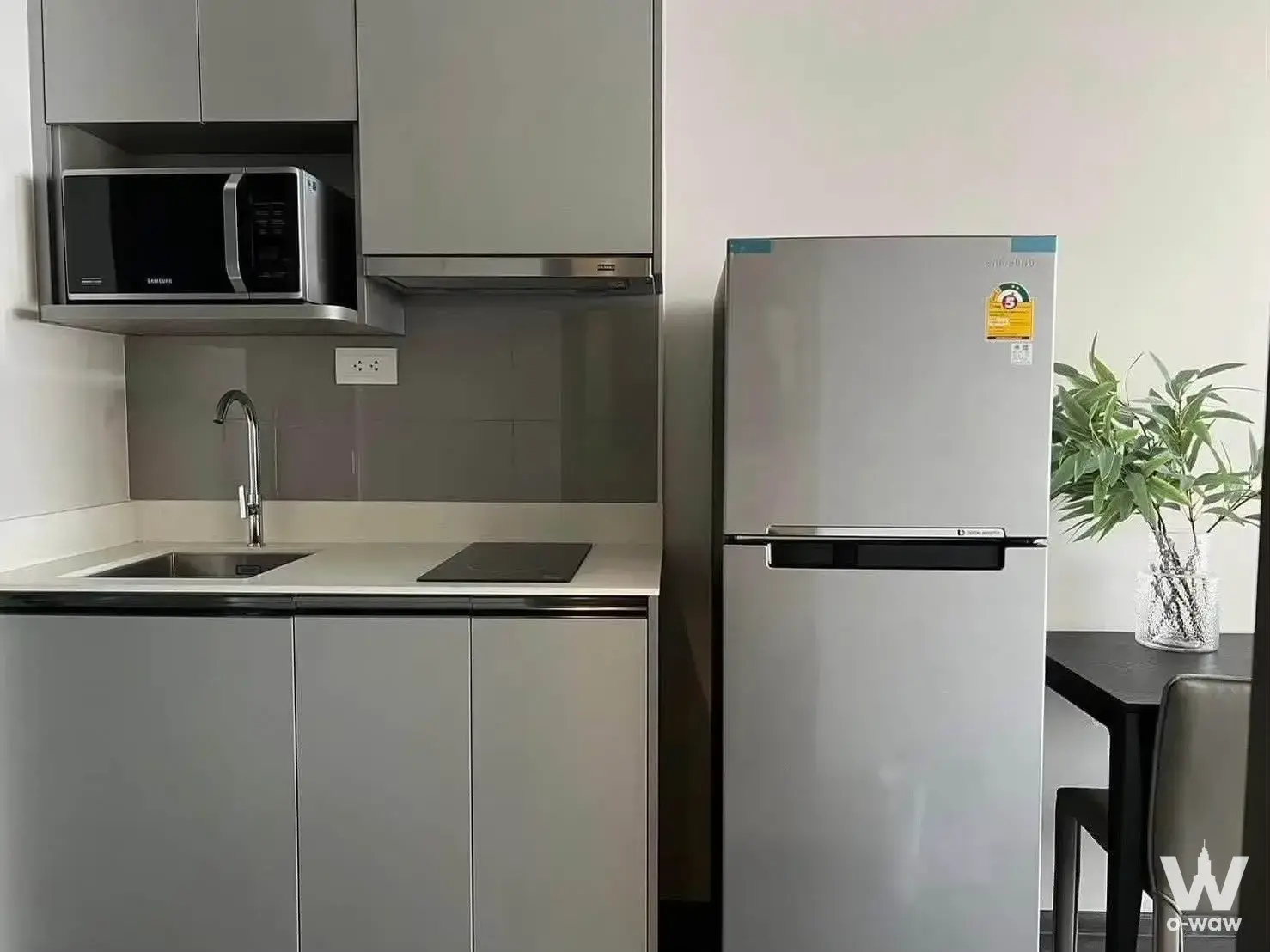 Grey kitchen cabinets with stainless appliances in this 1-bed Ideo Mobi Rangnam rental unit