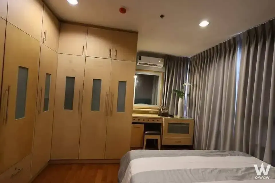 Pathum Wan Resort 2-bed bedroom featuring light-wood wardrobe and vanity desk