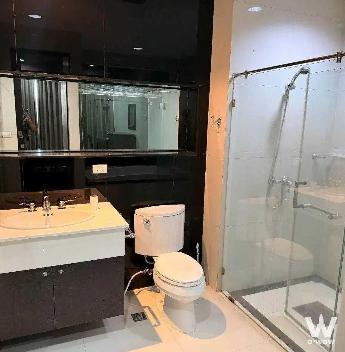 Modern bathroom in The Address Chidlom featuring a floating vanity and glass-enclosed walk-in shower