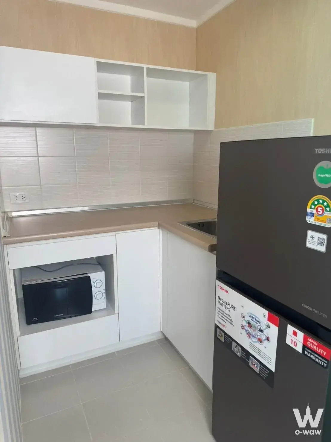 Compact kitchen in Lumpini park Rattanathibet-Ngamwongwan with white cabinets and stainless sink