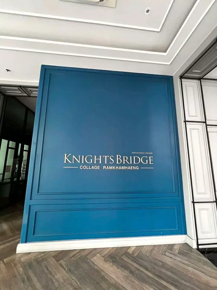Lobby entrance of KnightsBridge Collage Ramkhamhaeng featuring a teal feature wall and herringbone tile floor