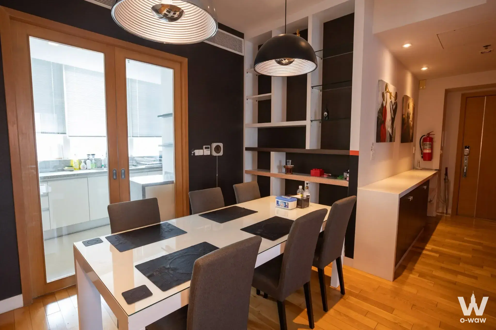 Dining room in a 3-bed Millennium Residence condo for sale with glossy table and built-in open shelving