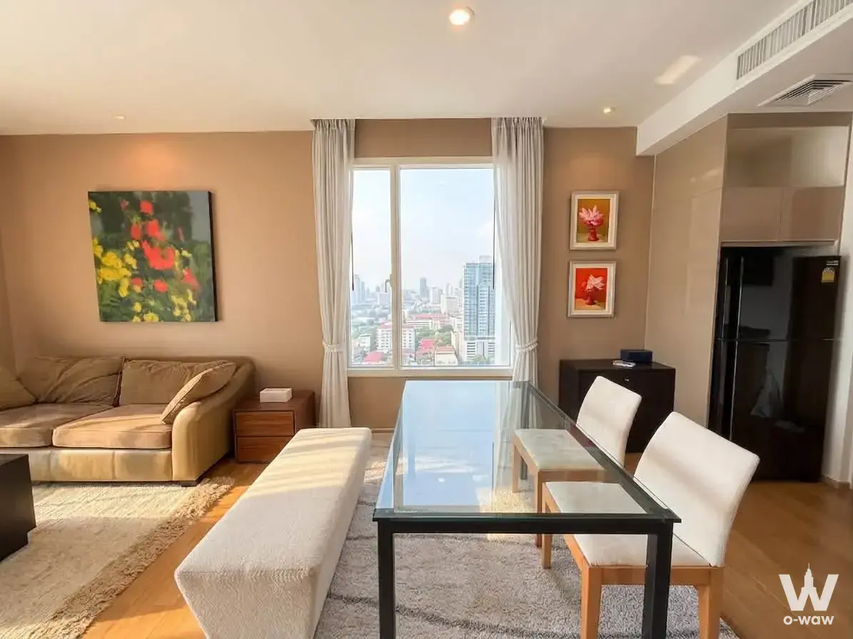 39 by Sansiri 2-bed condo living area with beige sofa and colorful floral art