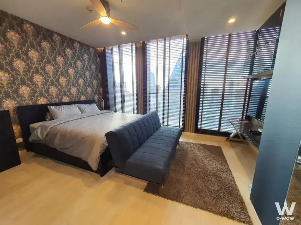 Noble Ploenchit bedroom with floral wallpaper accent and high-floor city view