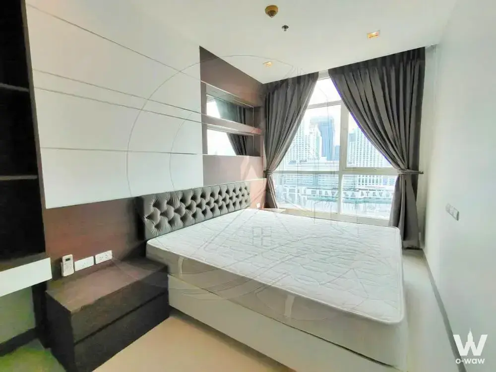 Master bedroom in this 2-bed rental at Ideo Verve Ratchaprarop with grey headboard and city skyline view