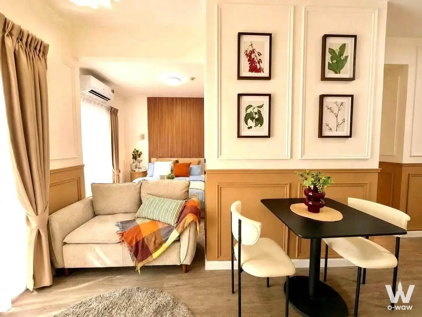 1-bed condo for sale in A Space Condominium with open-plan living, beige sofa, and botanical prints