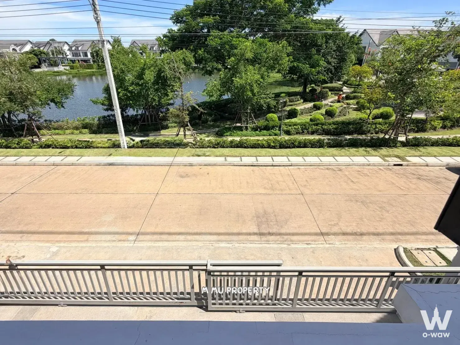 Balcony view of pond and suburban estate from a Burasiri Panya-Indra six-bed condo