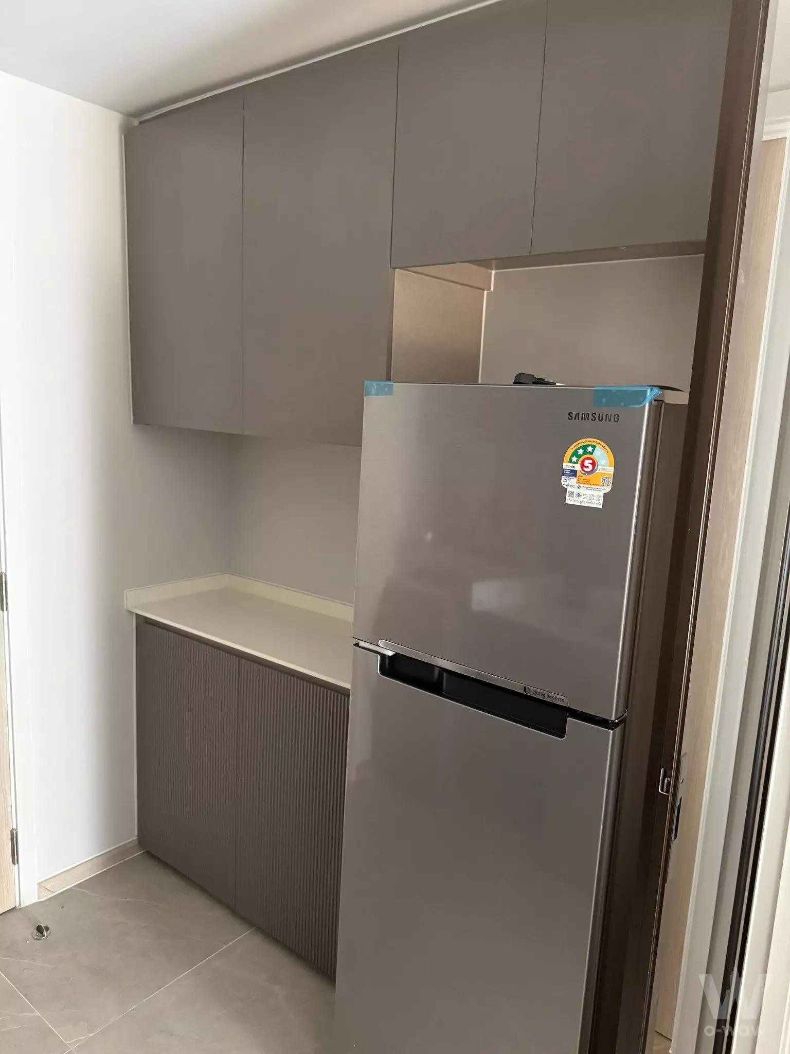 Modern kitchenette with tall matte grey cabinets and Samsung fridge in Chapter Thonglor 25 condo