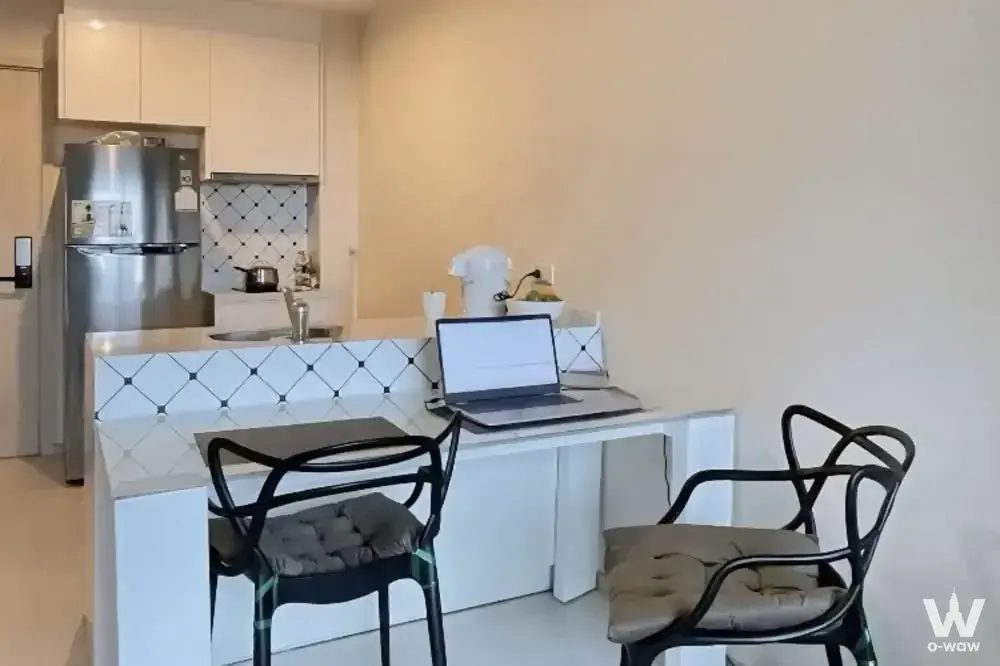 Modern kitchen in Rhythm Sukhumvit 42 with white cabinets, stainless fridge, and built-in desk for work
